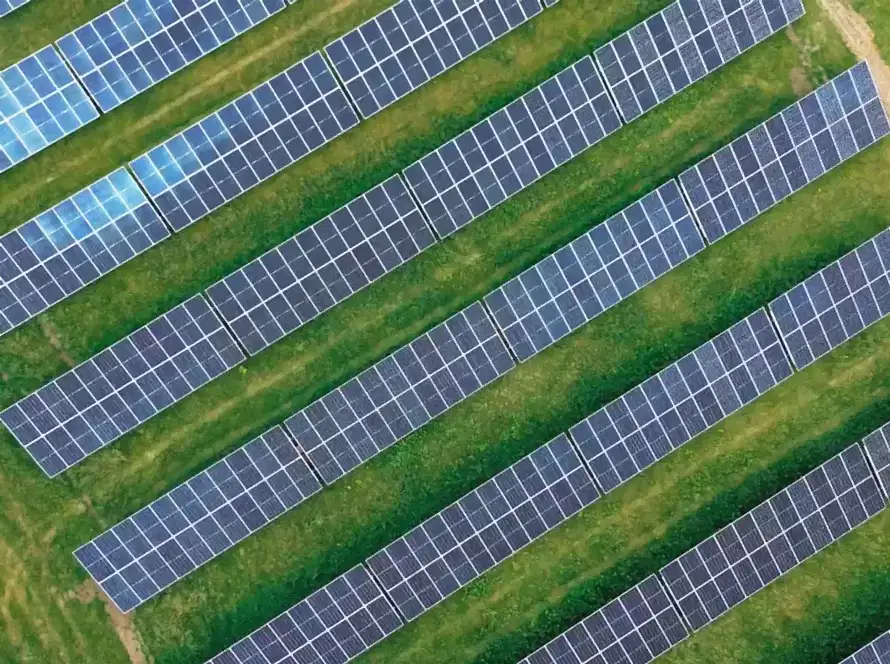 Yeşil tarla üzerinde kuşbakışı açıyla görülen, off-grid ve on-grid güneş enerji sistemleri farkını yansıtan güneş panelleri.